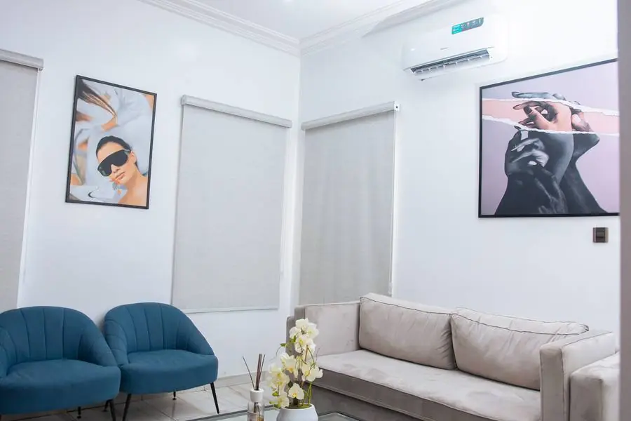 Lounge and waiting area at Beth Beauty Aesthetic Institute with framed skincare artwork and blue accent chairs