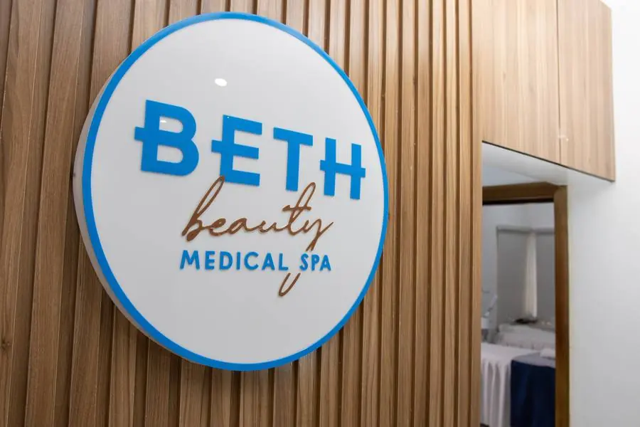 Beth Beauty Aesthetic Institute circular logo sign mounted on a wood-slat wall